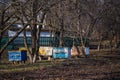 row of old yellow and blue hives on old apiary. large apiary to remove bee uteruses on point. Preparing bees for