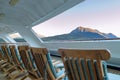 Wood deck lounge chairs at sunrise, stern verandah of cruise ship, Skagway, AK. Royalty Free Stock Photo