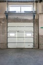 Row of overhead sectional doors in a multi-seat car garage. Inside view Royalty Free Stock Photo