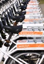 Row of parked city bikes for rent with bumper stickers saying Save CO2 and Green energy.