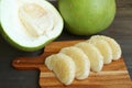 Row of Peeled Pomelo Segments with Opened in Half and Whole Fruit in the Backdrop Royalty Free Stock Photo
