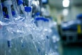 A row of plastic bottles filled with water, neatly lined up against a wall, Catheters and IV bags in a sterile environment, AI