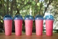 A row of plastic glass iced pink sweet milk is a milk drink mix with sweet red water drink with blue lid Royalty Free Stock Photo