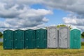 Row of plastic portable toilets at an outdoor event Royalty Free Stock Photo