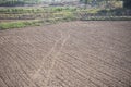 Row in a plow field prepared for planting crops in spring - plowed field with truck in agricultural farm countryside Royalty Free Stock Photo