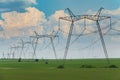 Row of power line support pylons on the countryside field Royalty Free Stock Photo