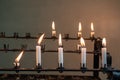 Stand of burning prayer candles in old church Royalty Free Stock Photo