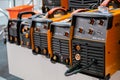 Row of protective welding mask helmets on table at exhibition, trade show