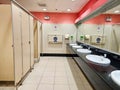 Row of public restrooms and white ceramic wash basins Royalty Free Stock Photo