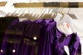 Row of purple blouse garments on display
