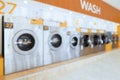 A row of qualified coin-operated washing machines in a public store. Royalty Free Stock Photo