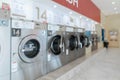 A row of qualified coin-operated washing machines in a public store. Royalty Free Stock Photo