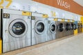 A row of qualified coin-operated washing machines in a public store. Royalty Free Stock Photo