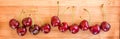 Row of real cherries on wooden background, summer fruit panorama