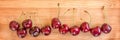 Row of real cherries on wood background