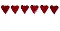 Red ceramic Valentines hearts on a white paper background