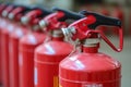 A row of red fire extinguishers with black handles, showcasing safety equipment ready for emergency use Royalty Free Stock Photo