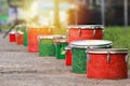 Row of red and green drums outside in the park