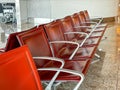 A row of red leather chairs are empty in a waiting room Royalty Free Stock Photo