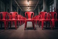 Row of red plastic chairs in an empty room. Toned, red chairs lined up in a row in a room, AI Generated Royalty Free Stock Photo