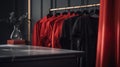 a row of red shirts hanging on a rack next to a table