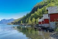 A row of red small houses with small boats at Flam village