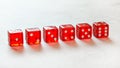 Row of red translucent craps dices showing all numbers from one to six, on white board Royalty Free Stock Photo