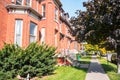 Row of renovated red brick houses along a street on a sunny day