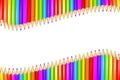 Row or ribbon of rainbow colored pencils over white background with copy space in the middle. Royalty Free Stock Photo