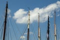 Row of sail boat mast tips and attached cables against a cloudy blue sky Royalty Free Stock Photo