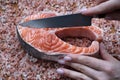 A row salmon steak in hands