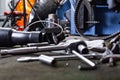 Row of screws and wrench tools on a floor in workshop near repaired old bike or motorcycle engine. Industrial scene with Royalty Free Stock Photo