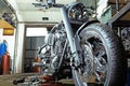 Row of screws and wrench tools on a floor in workshop near repaired old bike or motorcycle engine. Industrial scene with Royalty Free Stock Photo