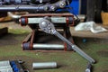 Row of screws and wrench tools on a floor in workshop near repaired old bike or motorcycle engine. Industrial scene with Royalty Free Stock Photo