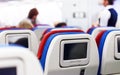 Row of seats with monitors inside of aircraft