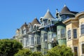 Row of seperate colorful house buildings or homes with green and gray facades and front yard trees with spure or turret Royalty Free Stock Photo