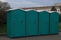 A row of a series of portable chemical outdoor toilets in the park