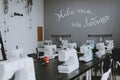 White sewing machines on the table. A row of sewing machines, a workshop for tailors Royalty Free Stock Photo