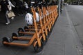 Row of shared Electric Kick Scooters or e-steps with helmets for rent in Melbourne, Australia