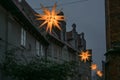 Row of shining Moravian stars between historic houses in the old town of Lubeck in Germany for advent and Christmas at night, copy Royalty Free Stock Photo