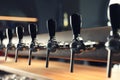 Row of shiny beer taps in pub Royalty Free Stock Photo