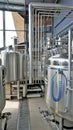 Row of shiny metal micro brewery tanks or Fermentation mash vats in Brewery factory Royalty Free Stock Photo