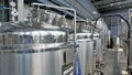 Row of shiny metal micro brewery tanks or Fermentation mash vats in Brewery factory Royalty Free Stock Photo