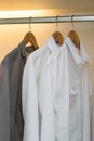 Row of shirts hanging in white wardrobe Royalty Free Stock Photo