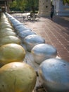 Row of silvery and golden alms bowls in buddhist temple