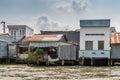 Row of simple houses along Kinh 28 canal in Cai Be, Mekong Delta, Vietnam