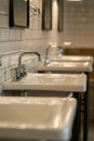 A row of sinks in a public restroom. Suitable for hygiene and architecture concepts Royalty Free Stock Photo