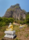 Row of sitting Buddha statues in Lumbini garden at the bottom of Royalty Free Stock Photo