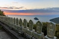 Row of small buddha statues outside temple overlooking sea at sunrise Royalty Free Stock Photo