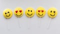 A row of smiley face merengue cookies on lollipop sticks. Royalty Free Stock Photo